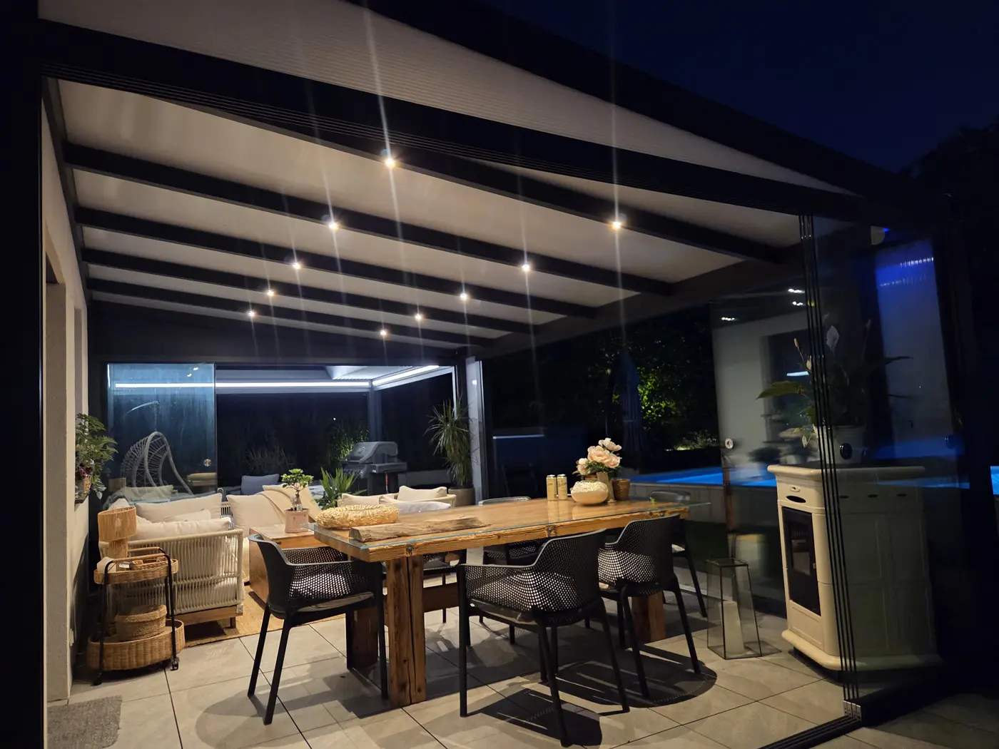 Terasová pergola večer s LED osvětlením zabudovaným v konstrukci střechy